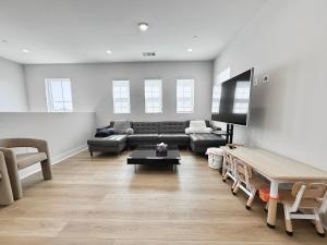 a living room with a couch and a tv at #Marbella Lane - Spacious 4BR Modern Family Home! in Placentia