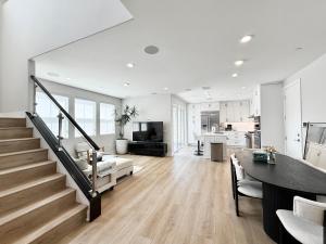 a living room with a staircase and a kitchen at #Marbella Lane - Spacious 4BR Modern Family Home! in Placentia