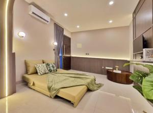 a living room with a couch and a tv at LuMen By SanLiving - 3BR - NICE Expo - Free Parking in Rawalumpang