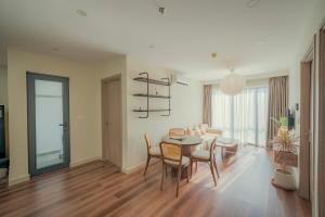 a dining room and living room with a table and chairs at Tobe in Hue 1 - Cozy Apartment with Pool and Gym & City View in Thôn Văn Dương