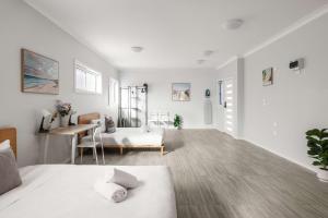 Dieses weiße Zimmer verfügt über ein Bett und einen Schreibtisch. in der Unterkunft Comfort Stay - Detached Quadruple Studio Room with Simple Kitchenette near Top Ryde city in Sydney