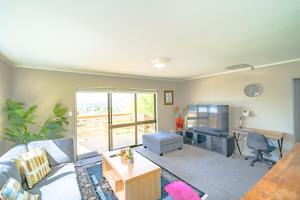 a living room with a couch and a desk at Gateway to Adventure in Rotorua +13 photos