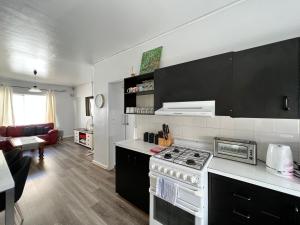 a kitchen with a stove and a living room at 2BR entire apartment beach in Glenelg