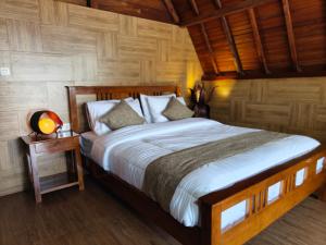 a bedroom with a large bed and a wooden wall at Qion's Villa in Cibogo +58 photos