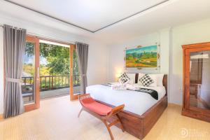 a bedroom with a bed and a chair and windows at Tinggian Hill Retreat in Nusa Penida +52 photos
