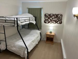 a bedroom with two bunk beds and a table at Cottages by Storybook Park in Burley
