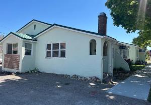 a white house with a brick chimney on a street at Cottages by Storybook Park in Burley