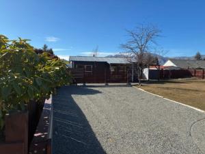 a driveway with a building in the background at Omarama Crib Spotless Scenic Base for Families in Omarama