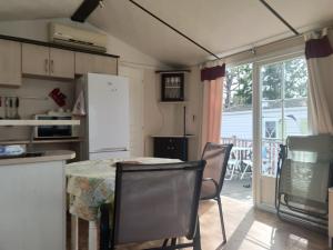 a kitchen with a table and chairs and a refrigerator at Mobilhome résidentiel in Gassin