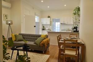 una sala de estar con un sofá y una mesa en Cozy Newtown Terrace, en Sídney
