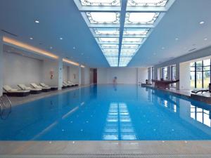 ein großes Schwimmbecken mit einer Person, die in der Mitte steht in der Unterkunft Dongguan Yingbin Hotel in Dongguan