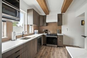 a kitchen with wooden cabinets and a sink at The Adelynn - New Luxury Build in Center of PDX in Portland
