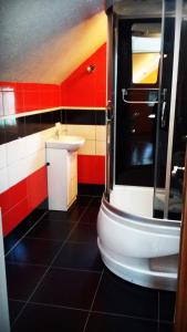 ストロニエ・シロンスキエにあるMieszkanko Nad Śliwkąの白い洗面台と赤い壁のバスルーム