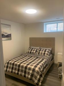 a bedroom with a bed with a black and white checkered blanket at Friendly Extended Stay and Comfort in Winnipeg