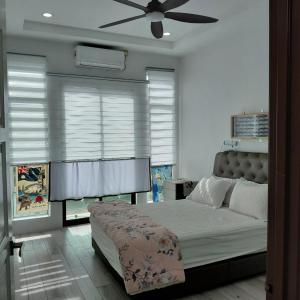 a bedroom with a bed and a ceiling fan at The Riceview Homestay Guest House in Changlun