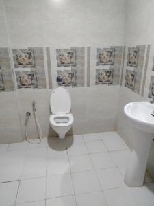 un baño con inodoro y lavabo en Shoba Guest House, en Gaurikund