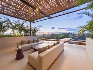 a living room with white furniture and a view of the city at Narawangsa Villa 4br Amazing Sunset Rooftop in Kerobokan