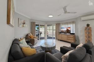 a living room with a couch and a tv at Villa Venezia Apt 3 - Spacious Hervey Bay esplanade apartment in Hervey Bay