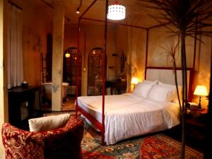 a bedroom with a canopy bed and a chair at DEMO Inn & Ine - Poetic Studio Stay by ATV in Hanoi