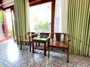 una stanza con un tavolo, due sedie e una finestra di Tam Coc Camellia Garden Homestays a Ninh Binh