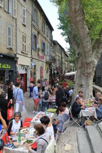 un grupo de personas sentadas en mesas bajo un árbol en Studio des Halles, en Aviñón