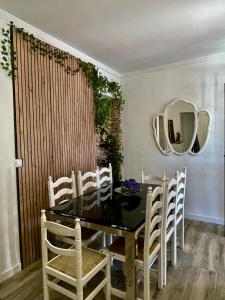 a dining room with a table and chairs and a mirror at Casa LuLa in Villafranca de Córdoba