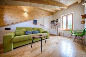 a living room with a green couch and a table at Apartments Villa Glorija in Komiža