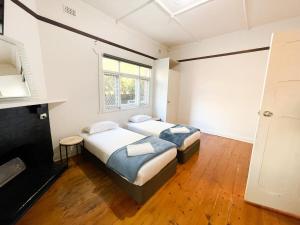 two beds in a room with a fireplace at big group house Westbourne park 