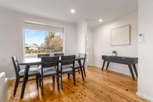 a dining room with a table and a piano at Blissful Blayney Home - Comfy Cosy and Sleeps 6 in Blayney