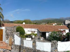 ein Haus mit einer Steinmauer und einem Zaun in der Unterkunft Casa Pepa in Granadilla de Abona