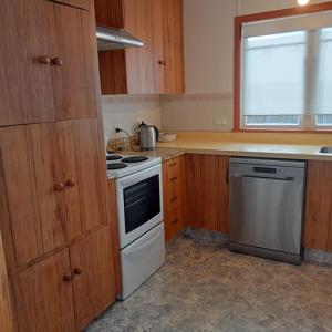 a kitchen with wooden cabinets and a stove top oven at Dated but Delightful on D'Arcy in Richmond +13 photos