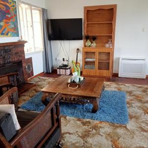 a living room with a wooden table and a tv at Dated but Delightful on D'Arcy in Richmond