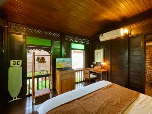 a bedroom with a bed and a desk and a window at Landmark Cenang in Pantai Cenang