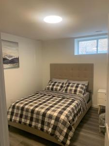 a bedroom with a bed with a black and white checkered blanket at Friendly Extended Stay and Comfort in Winnipeg