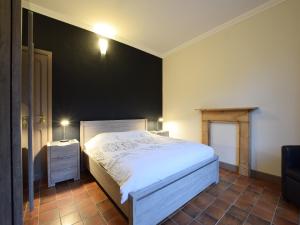 a bedroom with a white bed and a black wall at Holiday Home in Rogery with Sauna in Rogery