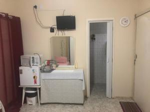a room with a microwave and a mirror on the wall at Suites Pitangueiras in Guarujá