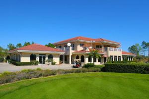 une grande maison avec une cour verdoyante dans l'établissement Oasis at the famous Southern Dunes golf course, à Haines City