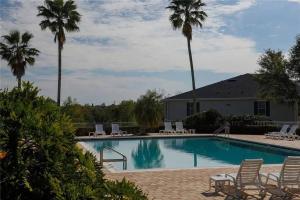 une piscine avec des chaises et des palmiers dans l'établissement Oasis at the famous Southern Dunes golf course, à Haines City