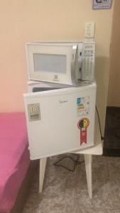 two microwaves are sitting on top of a table at Suites Pitangueiras in Guarujá