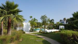 una casa con piscina y palmeras en Alcazaba Lagoon en Estepona