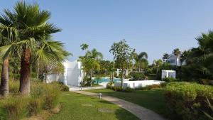 una casa con piscina y palmeras en Alcazaba Lagoon, en Estepona