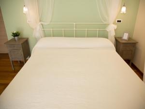 - une chambre avec un lit blanc et 2 tables de chevet dans l'établissement B&B Verdi Colline, à Controguerra