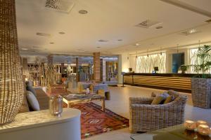 a lobby with couches and chairs and a table at Meliá Cala Galdana in Cala Galdana