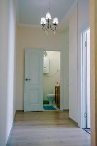 a hallway with a bathroom with a toilet and a chandelier at Apartments on Sobornaya Street near the waterfront in Mykolaiv