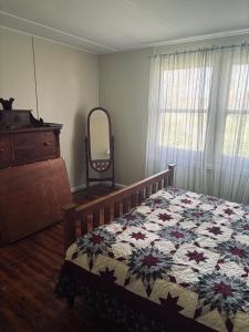 ein Schlafzimmer mit einem Bett, einer Kommode und einem Spiegel in der Unterkunft Thronum Cottage in Mangoplah