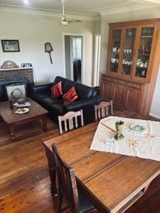 ein Wohnzimmer mit einem Tisch und einem Sofa in der Unterkunft Thronum Cottage in Mangoplah