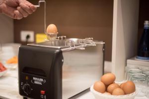 a person is holding a egg on top of a toaster at H2o in Sirmione