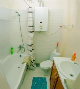 a bathroom with a toilet and a tub and a sink at Apartments on Sobornaya Street near the waterfront in Mykolaiv