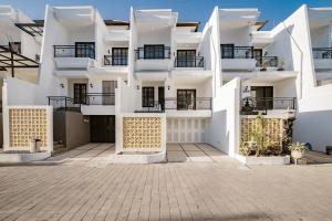 a white apartment building with balconies and a courtyard at Aurelia Home at Mogan Residence in Seminyak