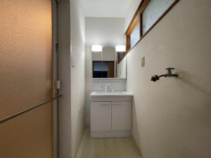 une salle de bain avec un lavabo et un miroir dans l'établissement eyehouse ozu No1, à Ozu